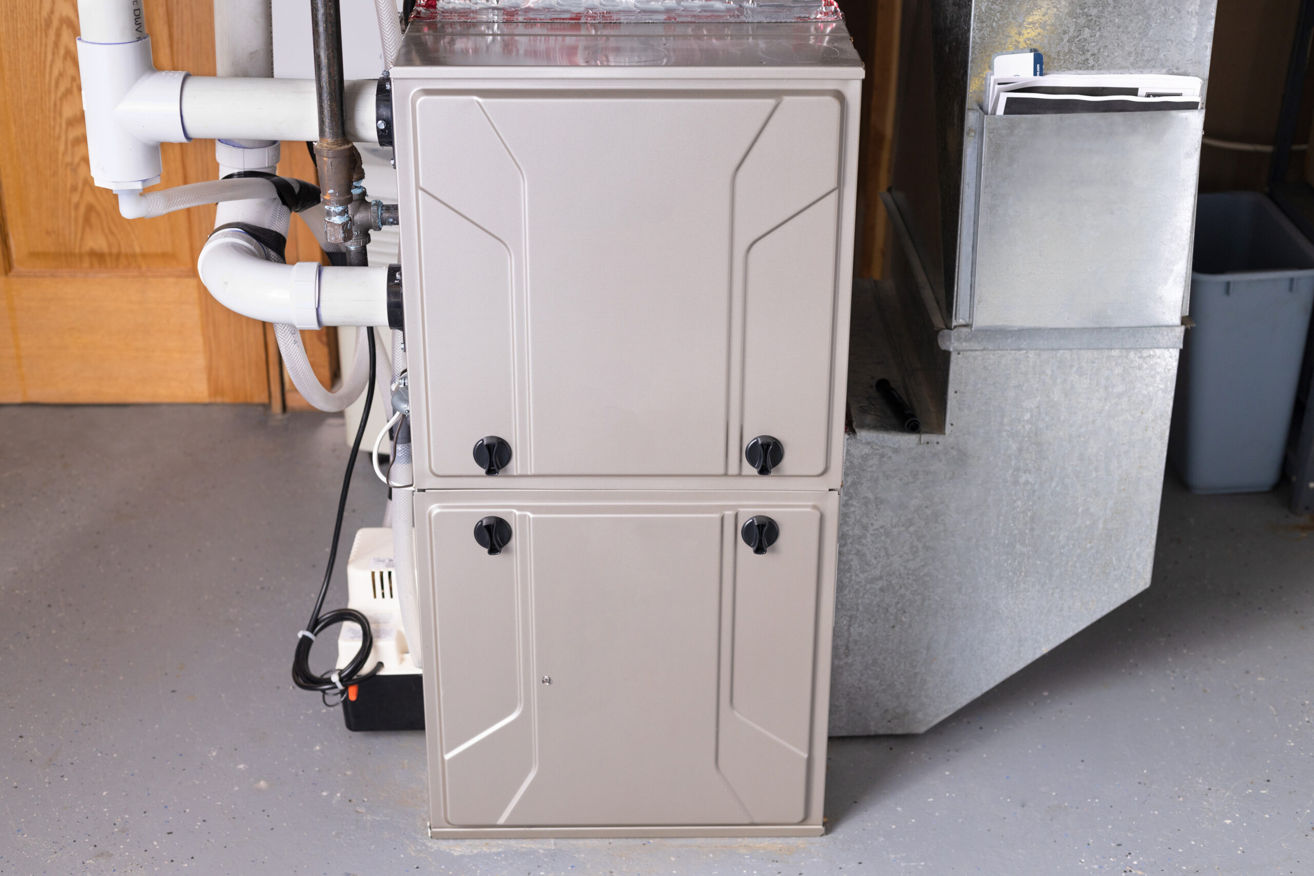 Modern home furnace with ventilation pipes.